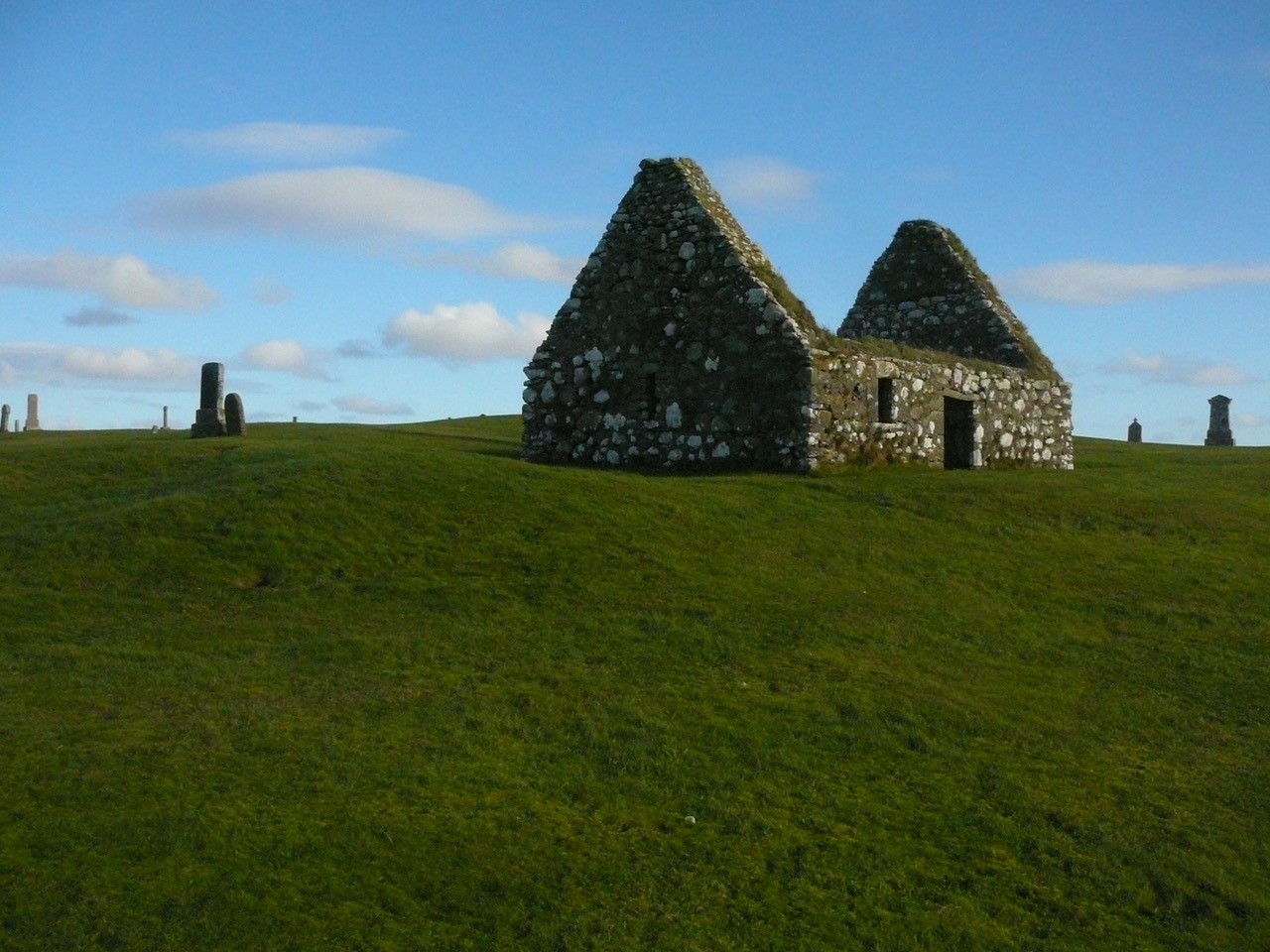 stone chapel on a grassy land with blue skies
